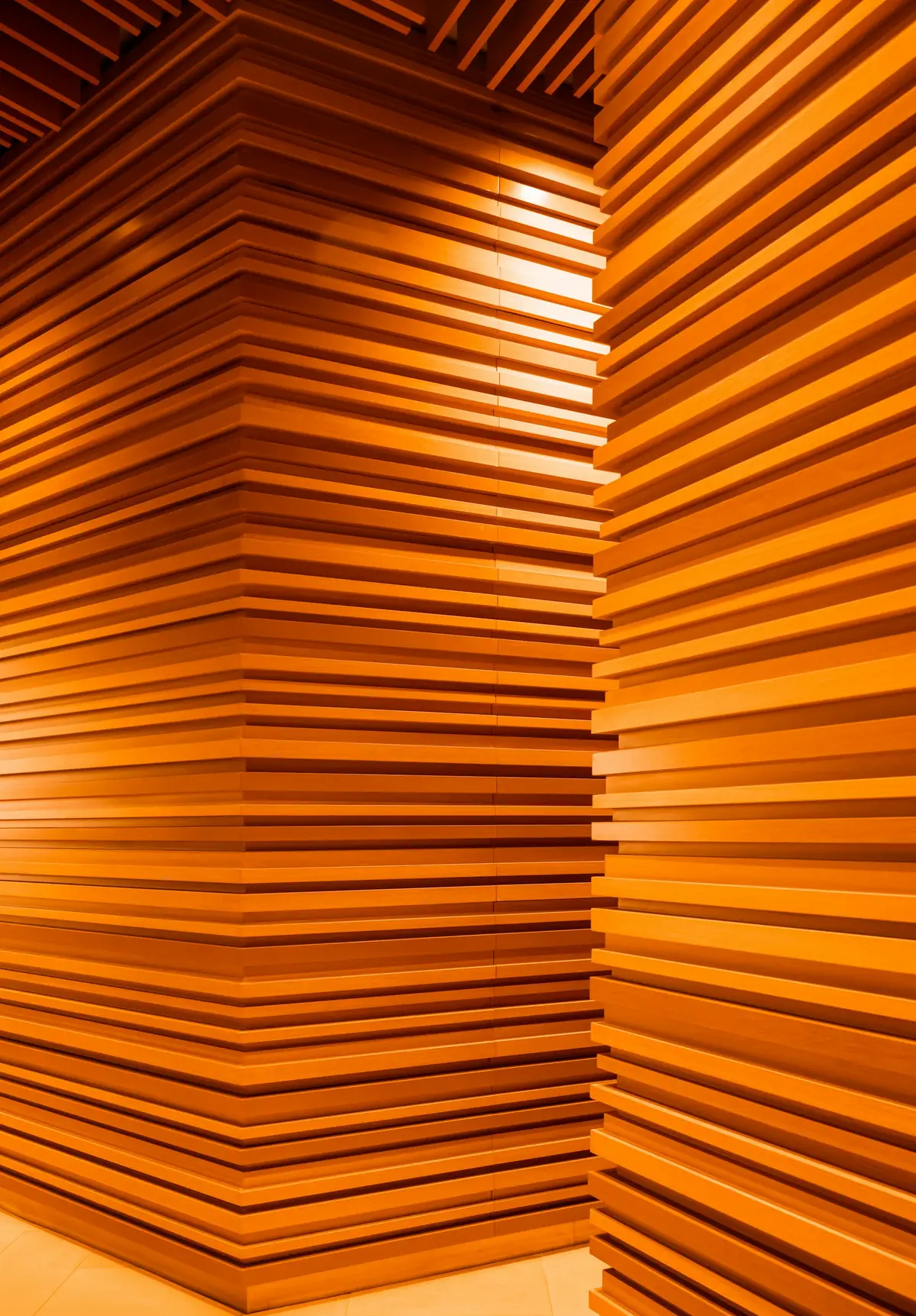 Pièce entièrement habillée de lames de bois orangé superposées
