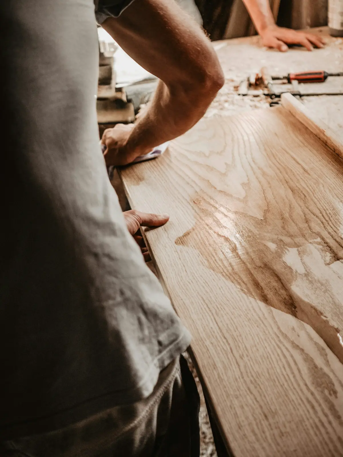 Mains qui emboîtent une lame de parquet en bois clair